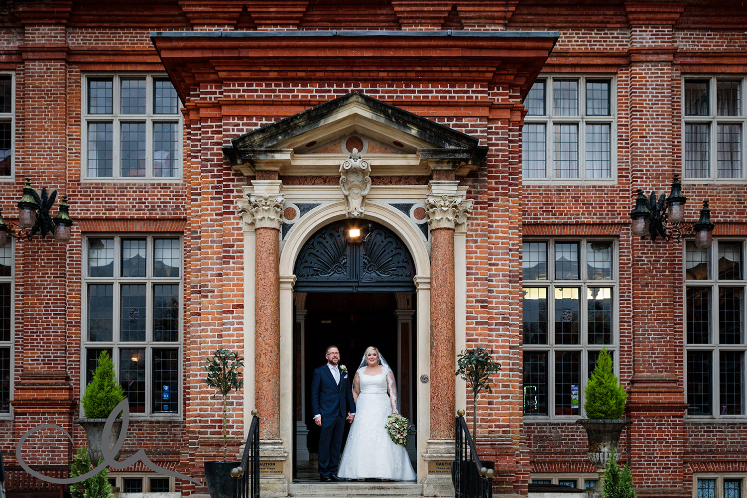 Newly weds have their portrait taken in front of Broome Park Wedding Venue Kent