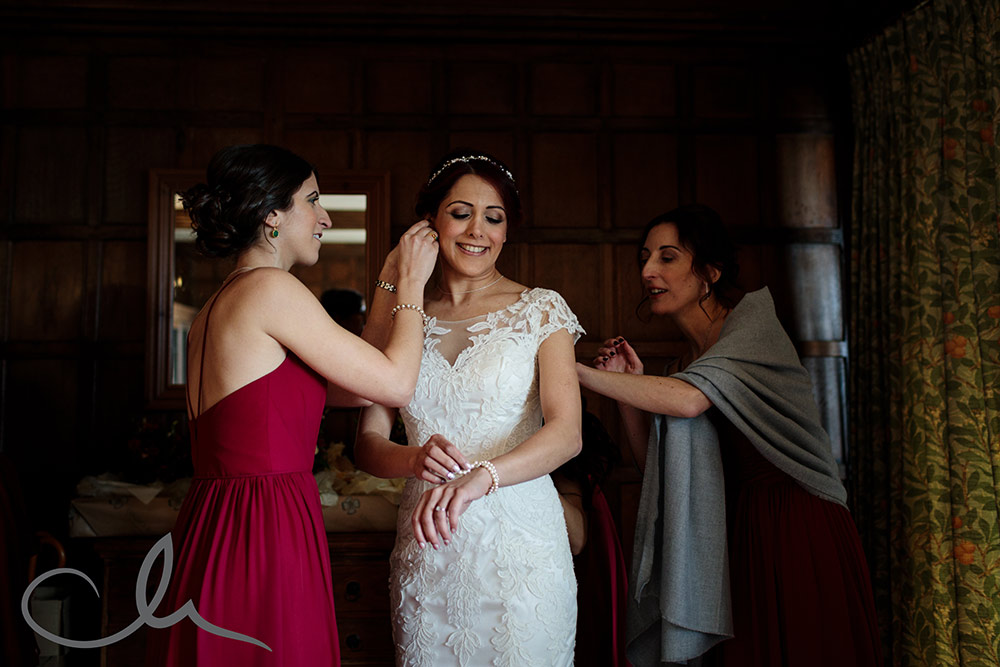 Bride has wedding dress put on with the help of her bridesmaids at Lympne Castle