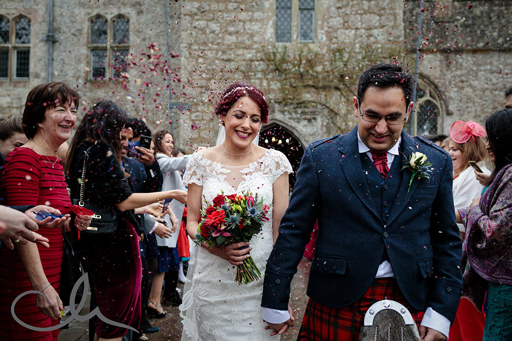 newlywed couple are showered with confetti at Lympne Castle Wedding