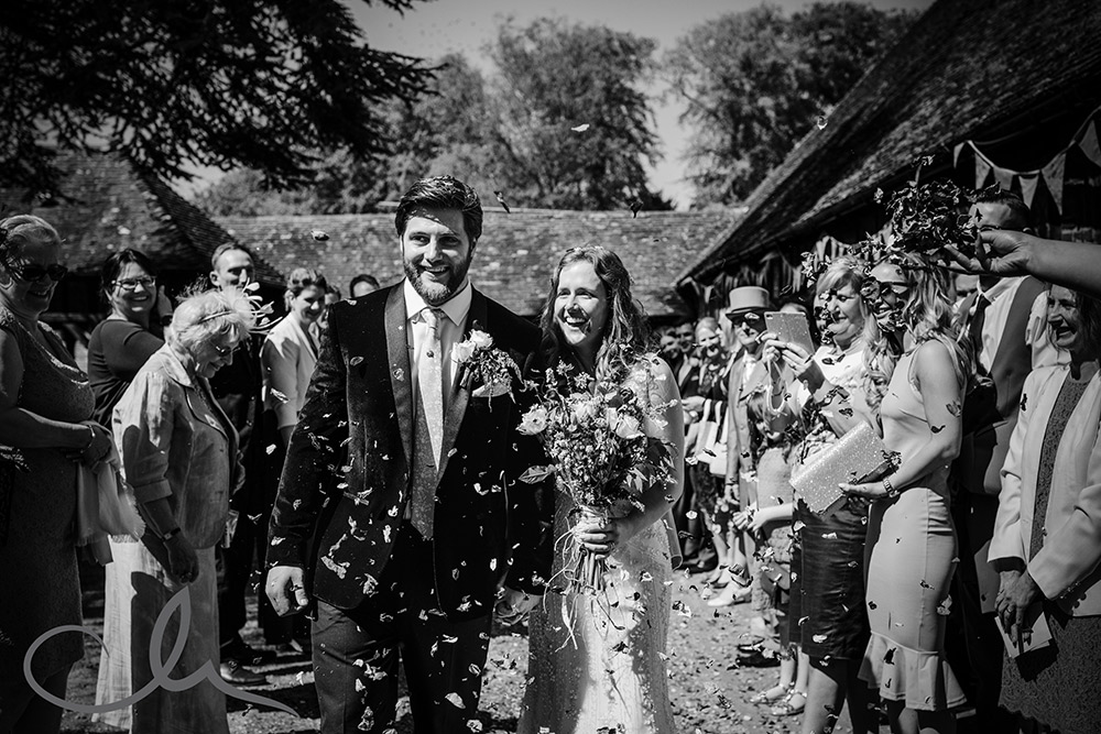 newlywed couple are showered with confetti