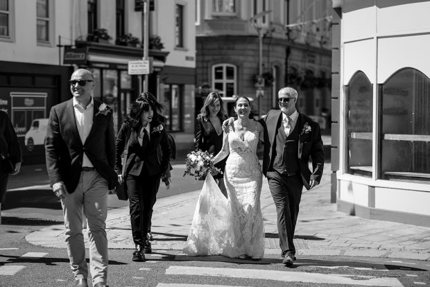 Jersey Wedding Photography - the newlyweds walk hand in hand through St Helier, Jersey