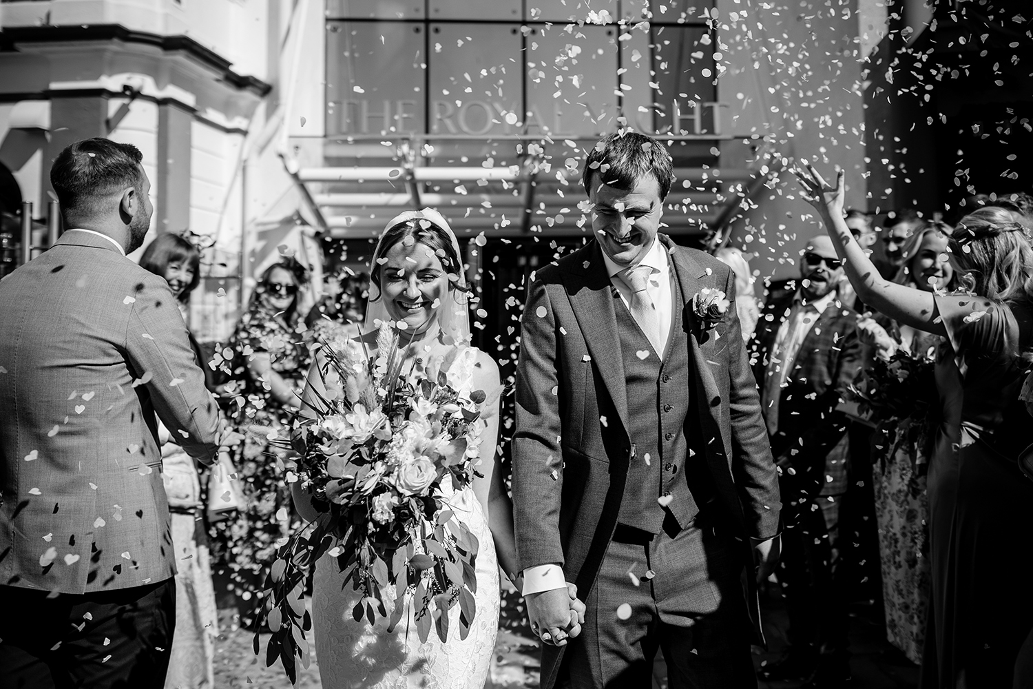 The bride and groom are joyfully showered with confetti at The Royal Yacht Hotel Jersey