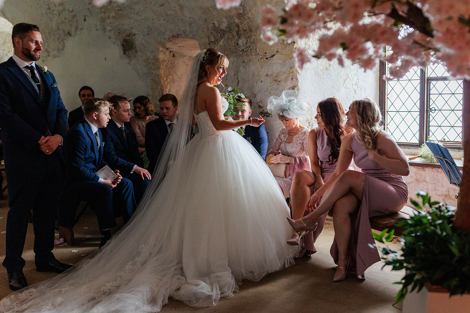 The bride speaks happily to her bridesmaids at Mont Orgueil Castle, Jersey. CI