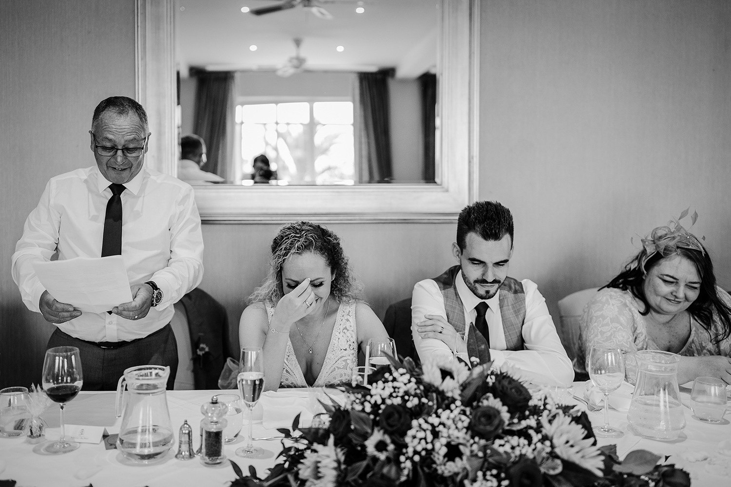 The bride is embarrassed by her father's tribute to her at her wedding reception at St Brelades Bay Hotel Jersey